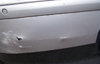 Ein silbernes Auto mit Stoßstangen Schaden